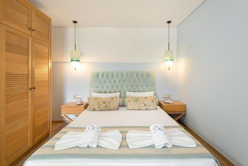 a bedroom with a bed with two pairs of shoes at Regos Resort Hotel in Neos Marmaras