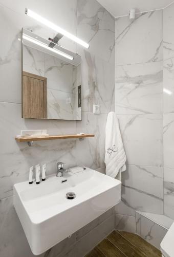 a white bathroom with a sink and a mirror at Regos Resort Hotel in Neos Marmaras