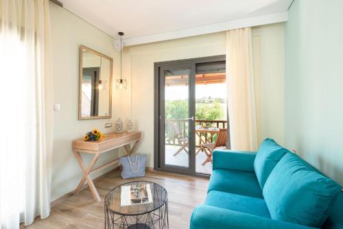 a living room with a blue couch and a table at Regos Resort Hotel in Neos Marmaras