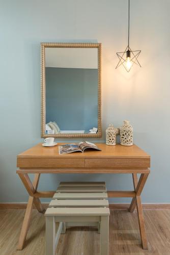 a dressing table with a mirror and a bench at Regos Resort Hotel in Neos Marmaras