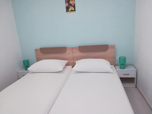two beds in a small room with two green cups at Apartman Čarija in Trogir
