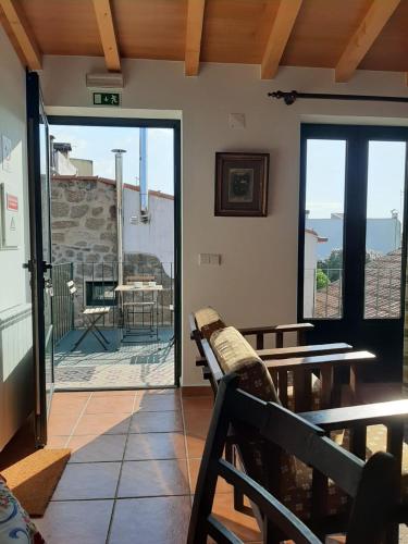 a room with a balcony with a view of the ocean at Charming apt in historic building in Serra da Estrela national park in Vinhó