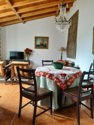 a dining room with a table and chairs and a chandelier at Charming apt in historic building in Serra da Estrela national park in Vinhó