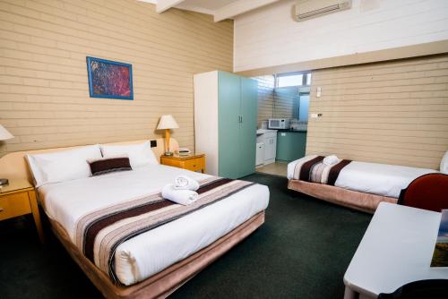 a hotel room with two beds and a kitchen at Parkview Motor Inn in Parkes
