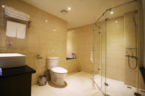 a bathroom with a toilet and a glass shower at J-HOTEL in Kaohsiung