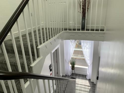 a stairway with a white railing and a window at Winckley Square Residences in Preston