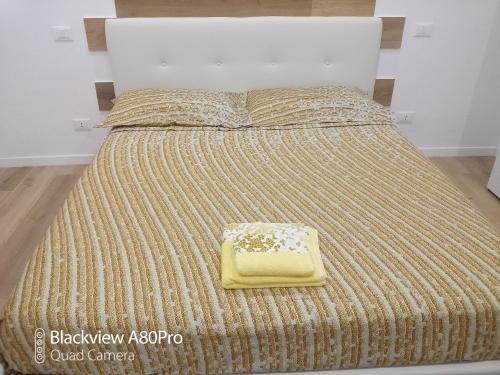 een groot bed met een gele deken erop bij Rosa House in Bologna