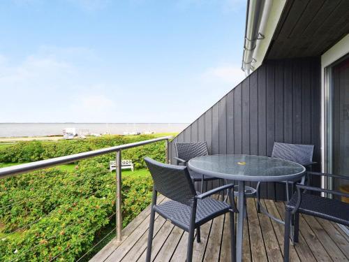 a balcony with a table and chairs and the ocean at 6 person holiday home in Hemmet in Falen