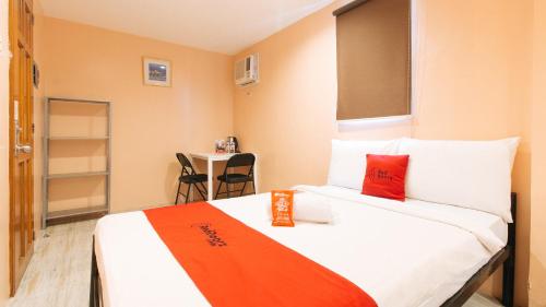 a room with a bed with an orange and white at RedDoorz at Hotel Rosemarie in Manila