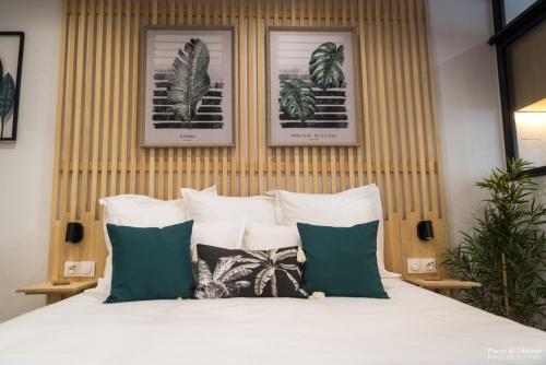 a bedroom with a bed with green and white pillows at Le Tilotine alizetropical in Le Moule