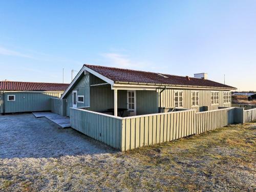 ein Gebäude mit einem Zaun davor in der Unterkunft 6 person holiday home in L kken in Løkken