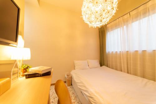 a bedroom with a bed and a chandelier at nestay apartment tokyo ikebukuro in Tokyo