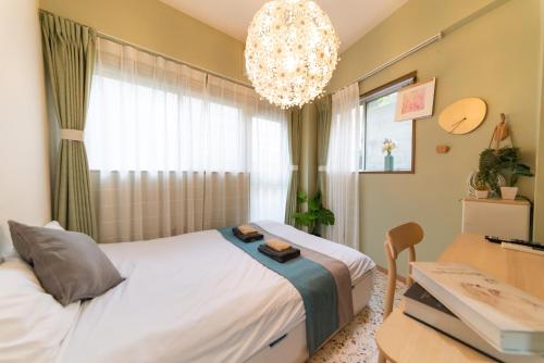 a bedroom with a bed and a desk and a chandelier at nestay apartment tokyo ikebukuro in Tokyo