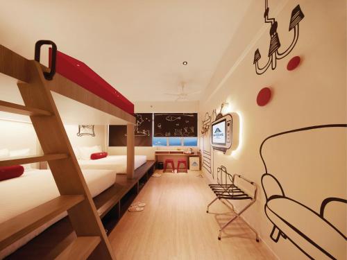 a room with two bunk beds and a desk at Resorts World Genting - Genting SkyWorlds Hotel in Genting Highlands