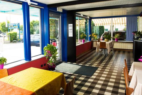 ein Restaurant mit blauen Säulen und einem karierten Boden in der Unterkunft Hotel Maria in Luisago