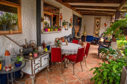 eine Küche mit einem Tisch und roten Stühlen in der Unterkunft La Casa de Mamá Coyita in Cartago