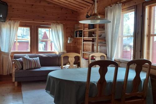 sala de estar con mesa y sofá en Mökki Jerisjärven rannalla en Muonio