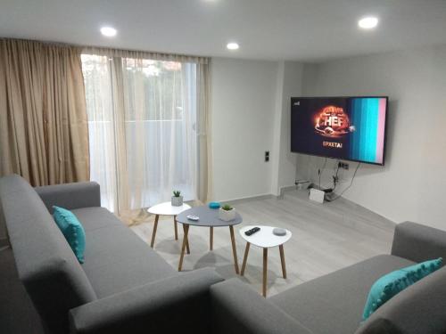 a living room with a couch and a flat screen tv at Malamatenia 's Maisonette in Mokhós
