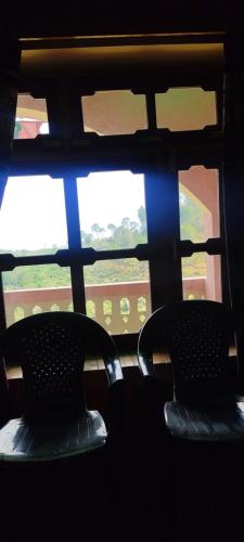 two chairs sitting in front of a window on a train at Ritu Raj Home Stay & Cafe in Malther