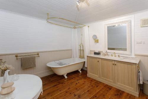 a white bathroom with a tub and a sink at Ivanhoe Park Homestead in Tamworth