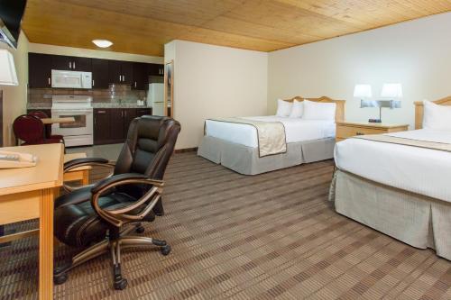 Cette chambre comprend deux lits et un bureau. dans l'établissement Econolodge Inn and Suites, à Medicine Hat