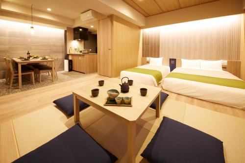 a hotel room with two beds and a table at MONday Apart Premium UENO in Tokyo