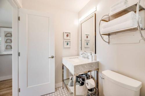 uma casa de banho com um lavatório, um WC e um espelho. em Sea-esta Suite with Ocean Views in Brentwood Bay em Brentwood Bay