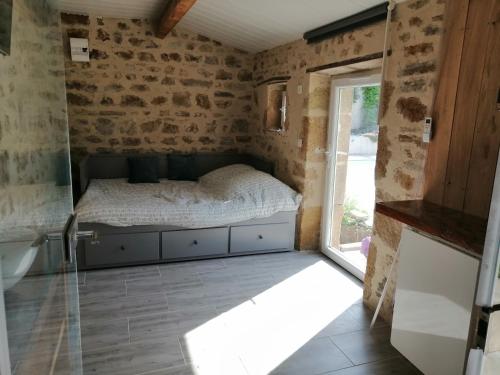 a small bedroom with a bed and a window at La salamandre in Vic-le-Comte