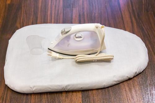 a white iron sitting on top of a white cushion at Rizo Zaizen Hotel in Ginowan