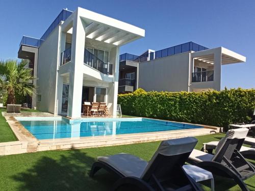 a house with a swimming pool in front of a house at Exclusive Villas in Kusadası