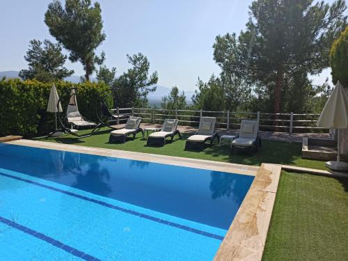 - une piscine avec des chaises et des parasols dans une cour dans l'établissement Exclusive Villas, à Kusadası