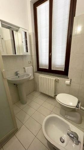 Baño blanco con lavabo y aseo en Casa Teresa INT 8 en Vigevano