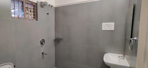 a bathroom with a shower and a sink at Garden House in Mysore