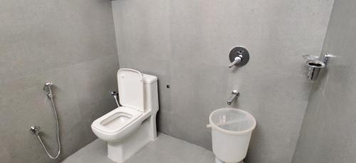 a bathroom with a toilet and a urinal and a sink at Garden House in Mysore