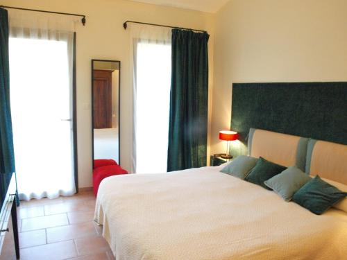 a bedroom with a large bed and a large window at Le relais d'Angélique in Lunel