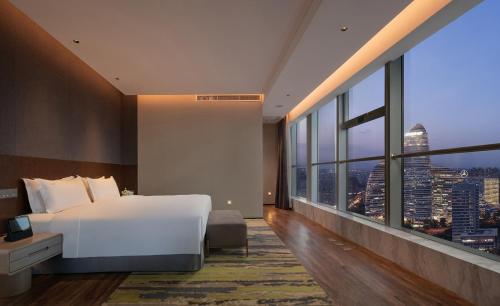 a bedroom with a large white bed and a large window at Holiday Inn Beijing Focus Square by IHG in Beijing