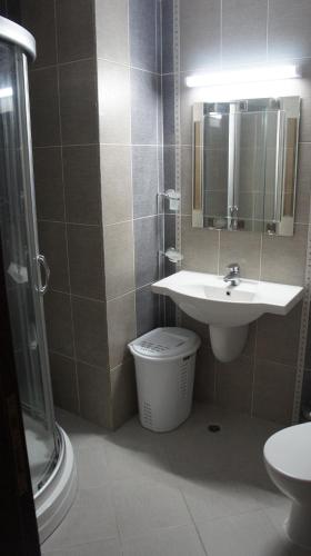 a bathroom with a sink and a toilet and a mirror at Семеен Хотел "Кораб Ренеса" in Ravda