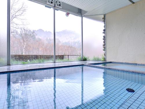 einen Pool mit Bergblick in der Unterkunft Ishinoyu Lodge in Yamanouchi