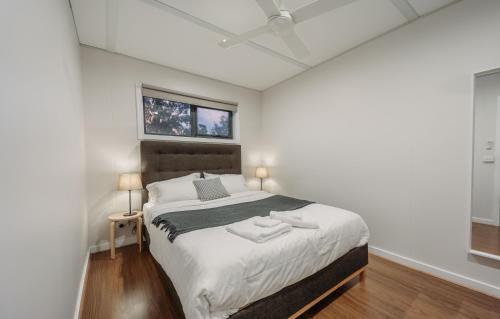 a white bedroom with a large bed with a ceiling at Vineyard Views at Shiraz Republic in Cornella