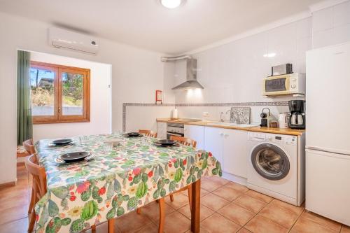 a kitchen and dining room with a table and a washing machine at Santa Eulalia in Can Picafort