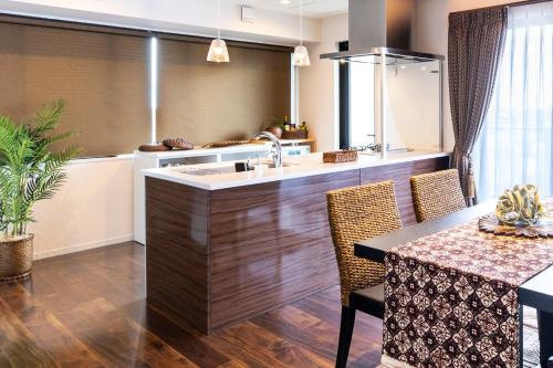 a kitchen with a sink and a table with chairs at Rizo Zaizen Hotel in Ginowan
