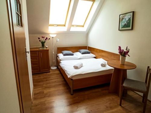 1 Schlafzimmer mit 2 Betten, einem Tisch und einem Fenster in der Unterkunft Apartamenty i Pokoje u Doroty in Karpacz