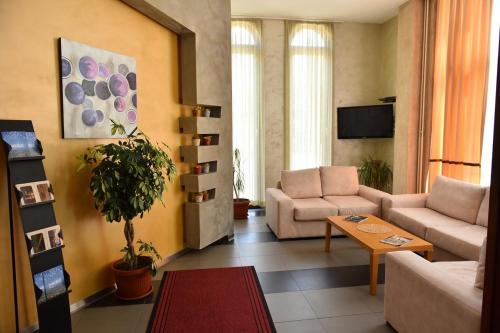 a living room with two couches and a tv at Hotel Vukov Most in Nikšić