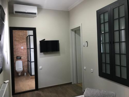 a room with a toilet and a television on the wall at D and D hotel in Tbilisi City