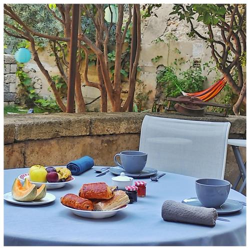 ein blauer Tisch mit Tellern voller Essen und zwei Tassen in der Unterkunft La Vigneronne des Costières in Vauvert