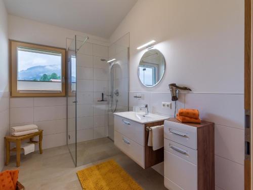 a bathroom with a sink and a shower with a mirror at Appartement Kirchner in Brixen im Thale