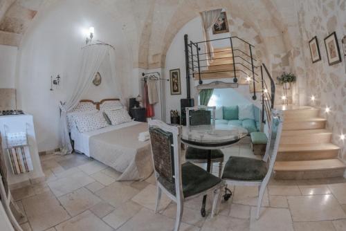 1 dormitorio con cama, mesa y escaleras en Dimora Baronia, en Latiano