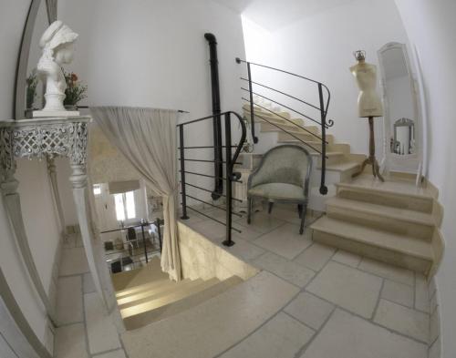 a hallway with stairs and a chair and a mirror at Dimora Baronia in Latiano
