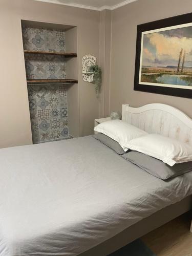 um quarto com uma cama branca e uma fotografia na parede em Les Sorbiers Barèges em Barèges