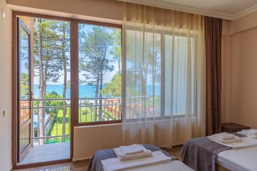 a hotel room with two beds and a large window at Samni Hotel in Ureki